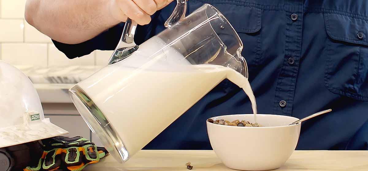 Photo of milk being poured into cereal.
