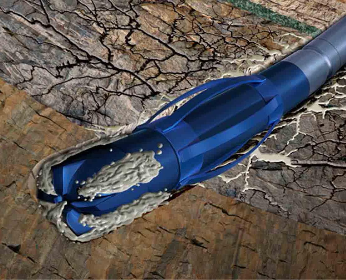Blue drill bit with cementing fluid drilling into rock formation.
