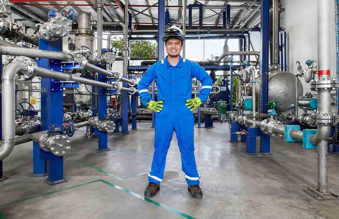 身穿蓝色工作服的男子站在工厂里(Tier 1_manufacingfacility _singapore _asia_15881)