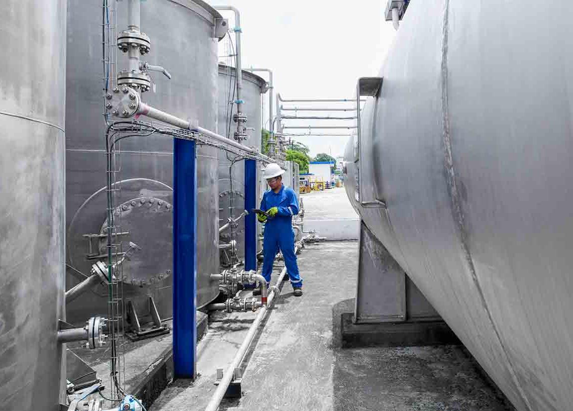 身穿蓝色工作服的监控水箱照片(Tier 1_manufacingfacility _singapore _asia_15896)