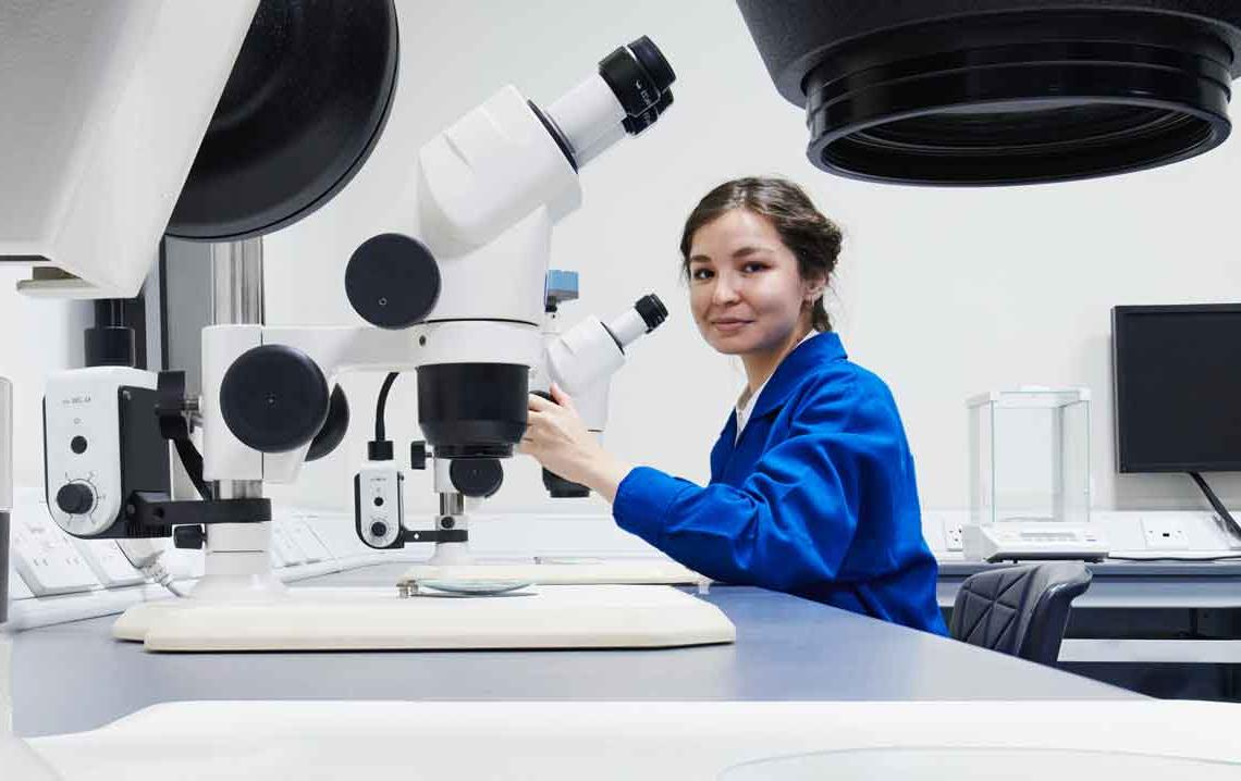 在科学实验室用显微镜工作的女人
