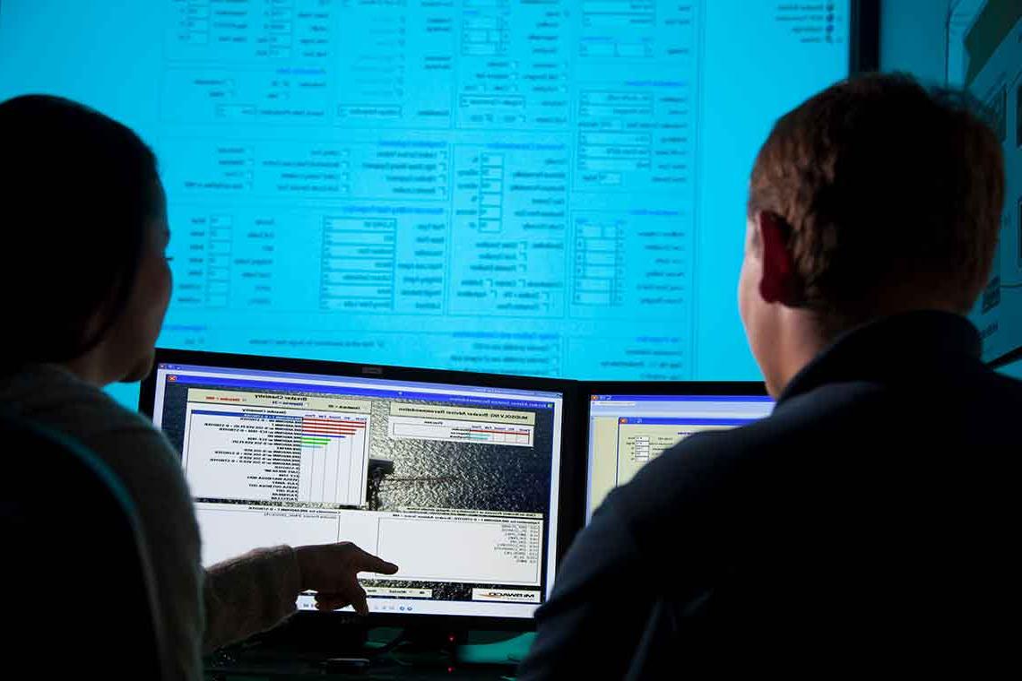 工作人员在电脑上查看钻井液模拟软件程序.