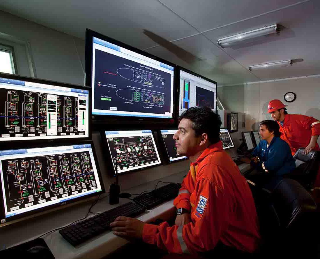 Schlumberger Workers in a DeepSTIM stimulation vessel Viewing Data on Monitors