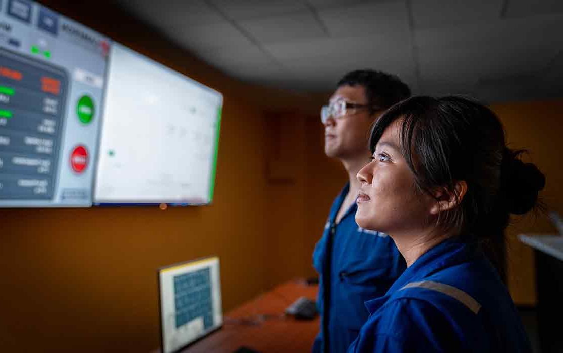 2名斯伦贝谢工程师——一男一女——正在检查显示器上显示的数据.